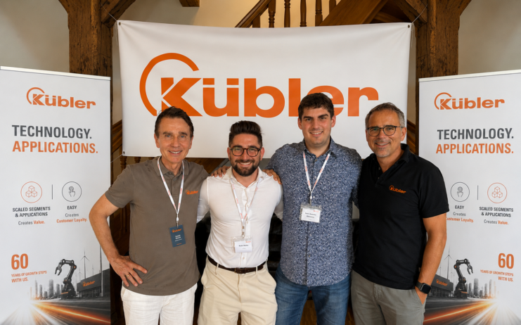Képen két oldalt: A Kübler tulajdonos-ügyvezetői, Gebhard és Lothar Kübler, Középen Ruska Robin és Robotka-Benkeházi Márk a Kvalix sales csapata. A több mint 600 fős, 12 nemzetközi leányvállalattal rendelkező Kübler Group világszerte 50+ országban szolgálja ki ipari partnereit.